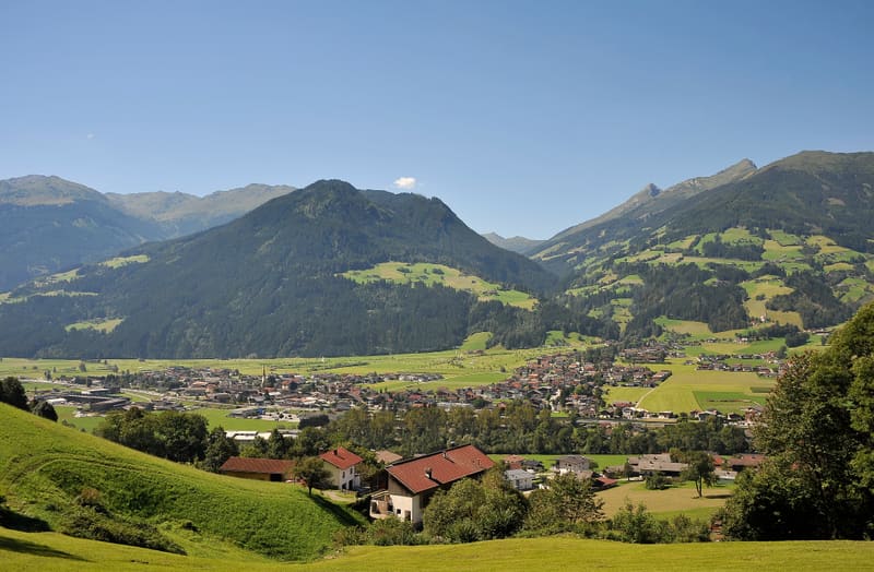 View over Uderns in summer with green meadows and the mountains of the Zillertal